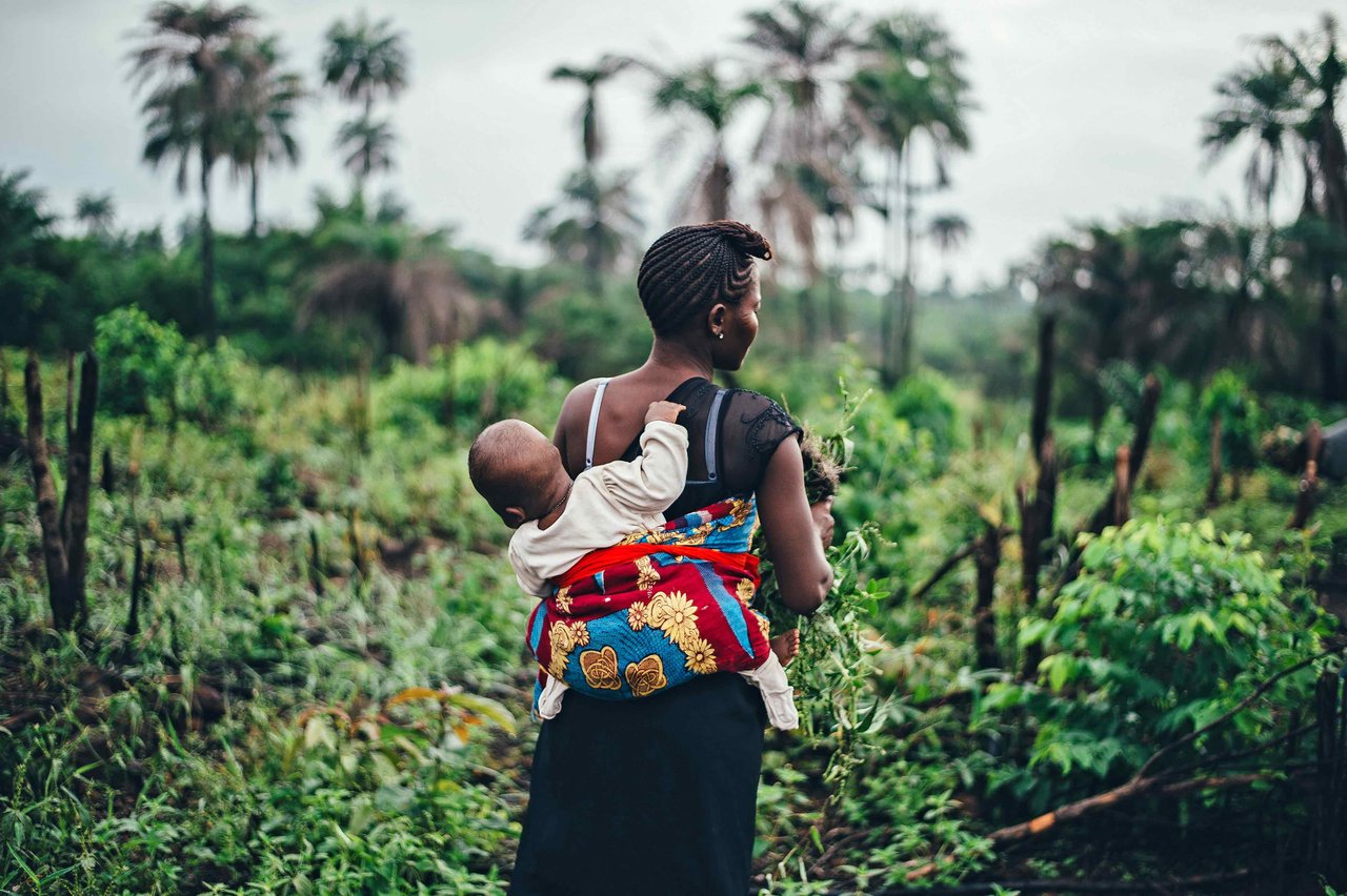Woman farmer, carrying a baby